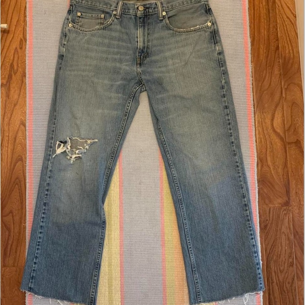 slightly worn down levi’s jeans with rip on the right knee